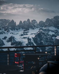 Cars on snowcapped mountains against sky during winter