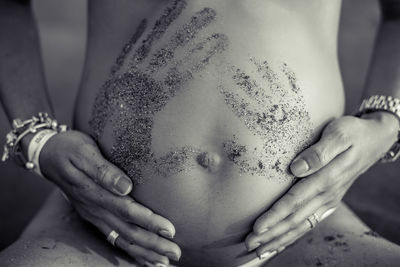Midsection of pregnant woman with hand print