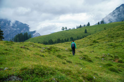 Woman hiking on alpine footpath in the austrian alps in the postalm region, salzburg.