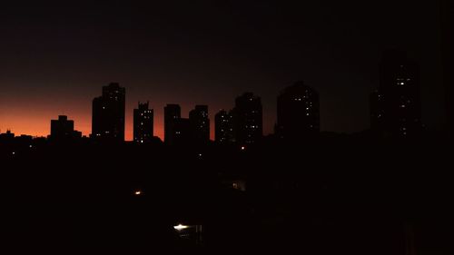 Illuminated cityscape against sky at night