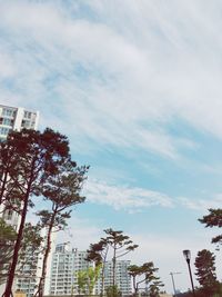 Low angle view of buildings against cloudy sky