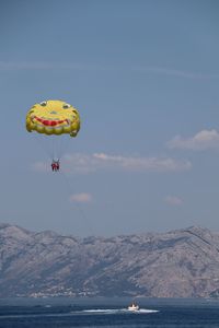 People paragliding over sea against sky