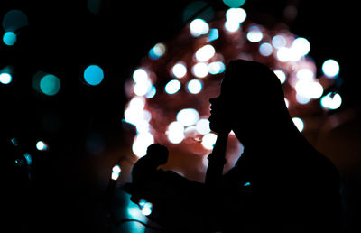 Close-up of silhouette people at illuminated nightclub