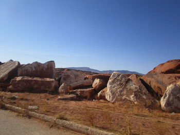 Rock formations on landscape against clear blue sky