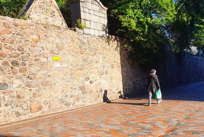 Rear view of woman walking by wall in building