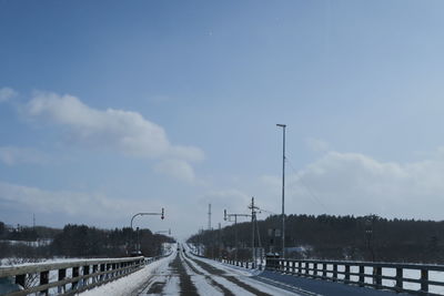 Road by bridge against sky