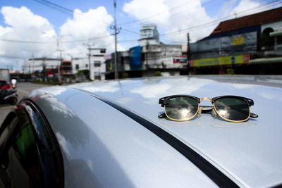 Reflection of sunglasses on car in city