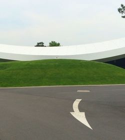 Road amidst grass against sky