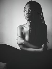 Close-up of young woman standing against white background