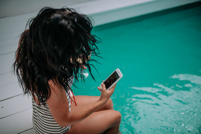 Woman using mobile phone in swimming pool