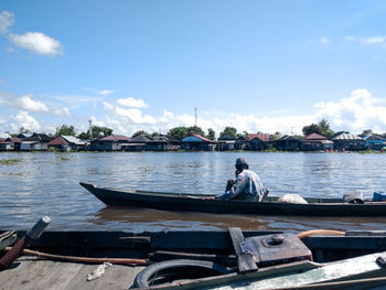 Boats sailing on river against sky