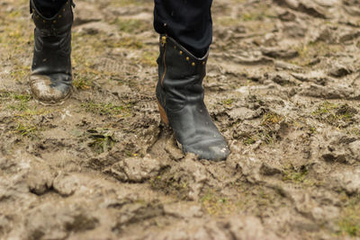 Low section of person walking on muddy field