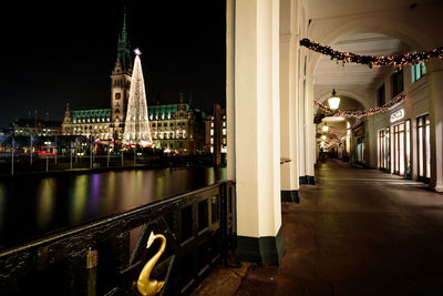 Illuminated buildings by river at night