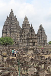 Tourists at a temple against sky