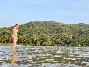 Woman standing on mountain against sky