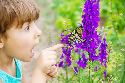 Close-up of girl blowing flowers