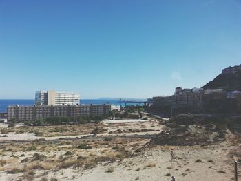 View of built structures against clear blue sky