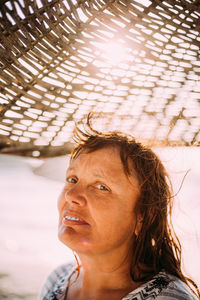 Adult caucasian woman relaxed posing under beach umbrella on sunset. vacation on sea ocean.