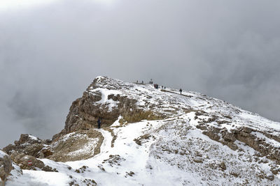 Low angle view of snowcapped mountain against cloudy sky