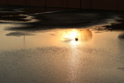 High angle view of silhouette wet car against sky during sunset