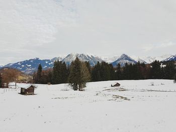 Scenic view of snow covered field against sky