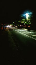 Cars on illuminated street at night