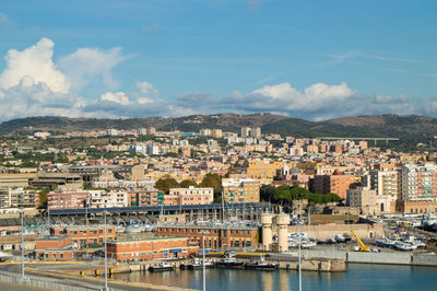 Aerial view of townscape by river against sky