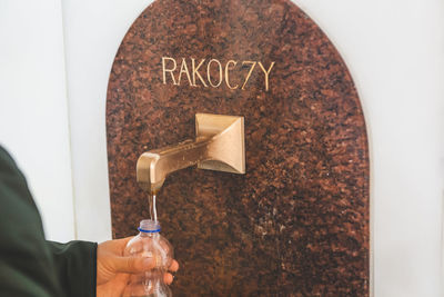 Cropped hands of man filling water in bottle