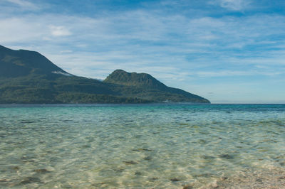 Scenic view of sea and mountains against sky