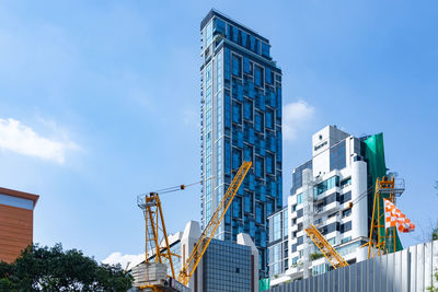 Low angle view of modern buildings against blue sky