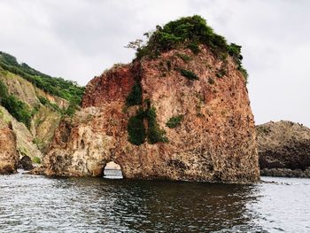 Rock formations by sea against sky