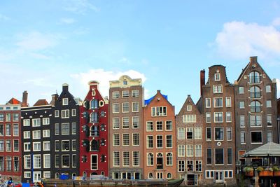 Low angle view of buildings against cloudy sky