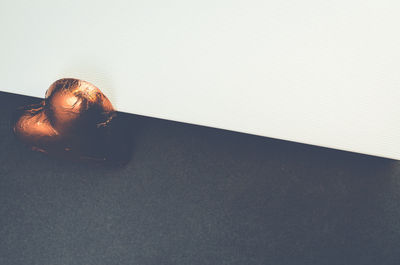 High angle view of heart shape chocolate on black table against white wall