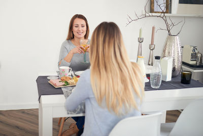 Friends talking while having breakfast at table