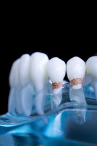 Close-up of dentures in water against black background