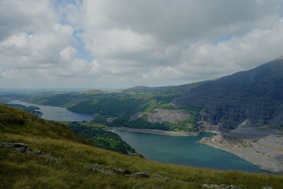 Scenic view of river by mountains against sky