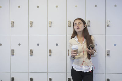 Young woman in workplace with her smart phone.