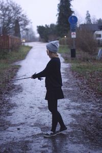 Rear view of woman walking on road