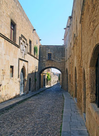 Street amidst buildings against clear sky