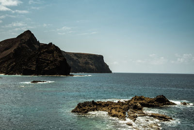 Scenic view of rock formation in sea against sky