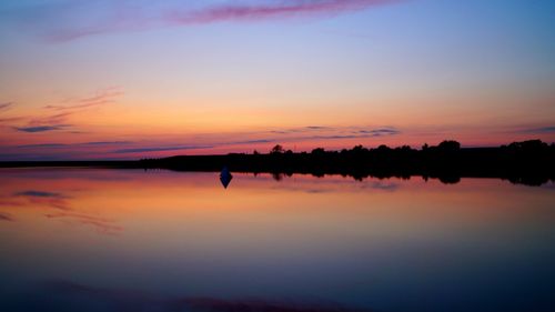 Scenic view of calm lake at sunset