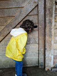 Curious boy looking through the door hole