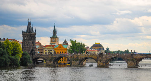 Arch bridge over river against buildings