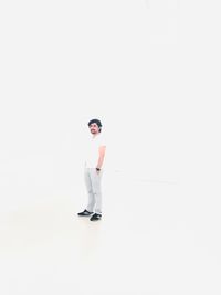 Portrait of young man standing against white background