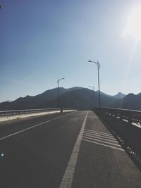 Road by mountains against clear sky