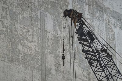 Low angle view of metallic structure against wall