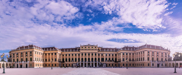 View of buildings in city against cloudy sky