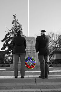 Rear view of people standing against sky