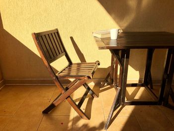 Minimalistic shot of wooden chair and table sitting in the bright sunlight