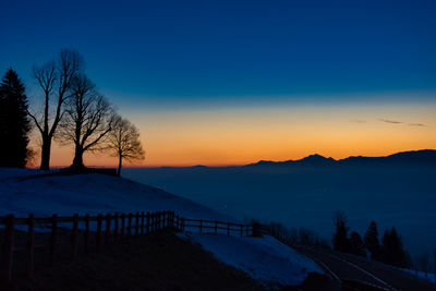 Scenic view of snowcapped mountains against sky at sunset